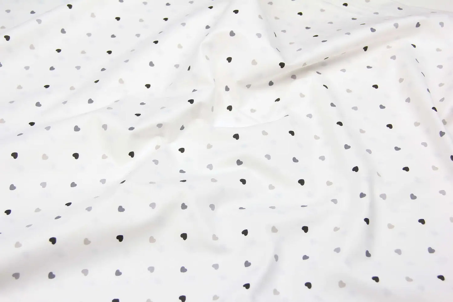 Baumwolllaken mit grauen und schwarzen Herzen auf weißem Grund